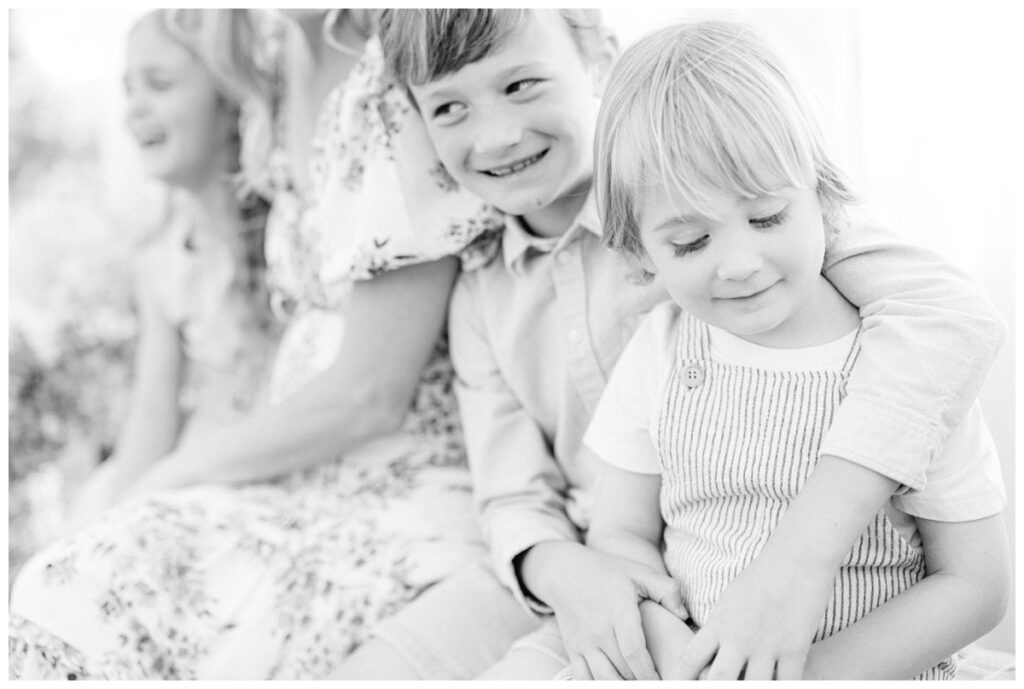 children sitting on bench with mom posing for portraits with Caroline Eidson Portraits