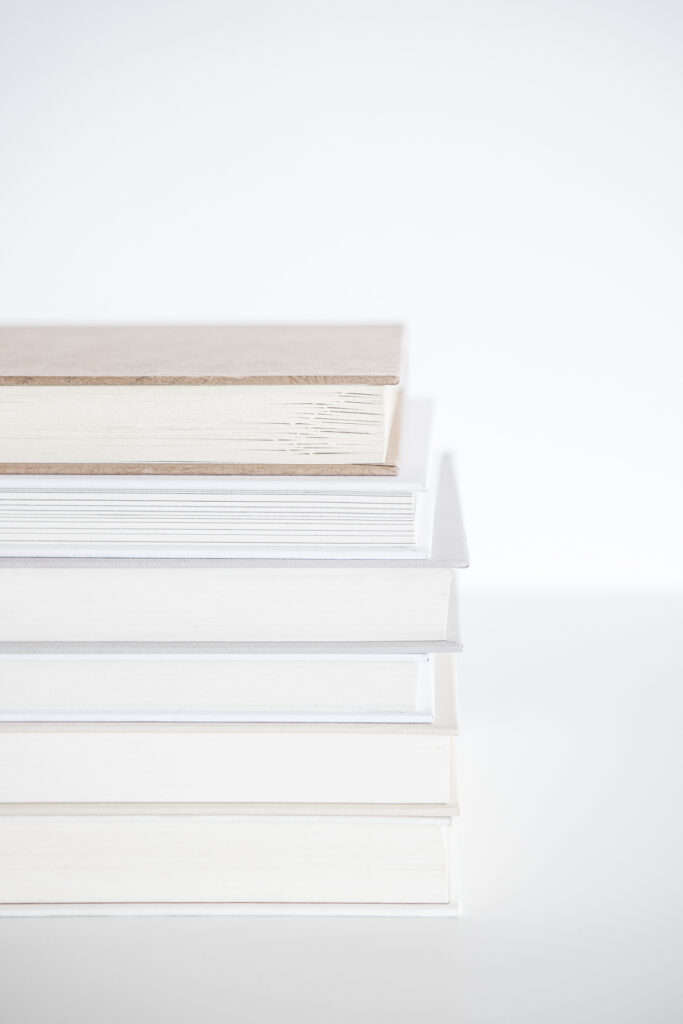 Stack of books on photographers white desk