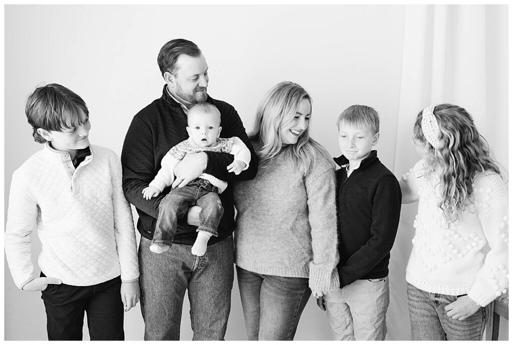 A relaxed family moment between parents and their four children during their Tulsa studio portrait session.
