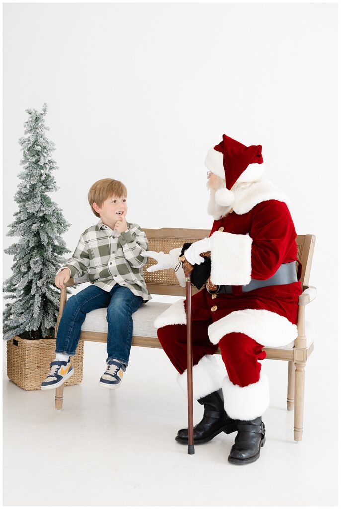 Young boy smiling as Santa surprises him during a Tulsa Santa mini sessions